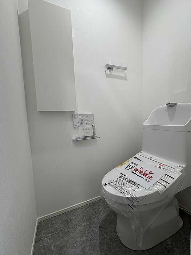 【【トイレ/2号棟】】ハイトーンのクロスでまとめられ、清潔感があります。温水洗浄便座付きですので、年間を通して、快適に使うことができます。操作しやすい壁面リモコンが採用されています。