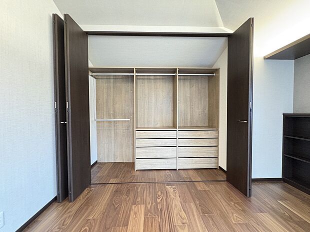【【クローゼット/洋室(約10.41帖)/A号棟】】システム収納付きのクローゼットです。引き出しやハンガーパイプなどが備えられ、お手持ちの洋服をたっぷりと収納することができます。/2026.7.16撮影