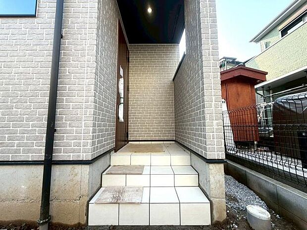 【【玄関】】屋根付きの玄関ポーチは、荷物が多い時や傘をさす際も濡れにくく、毎日の外出・帰宅をスムーズにサポート。細かな配慮が光る設計で、暮らしにゆとりと安心感を与えてくれる住まいです。