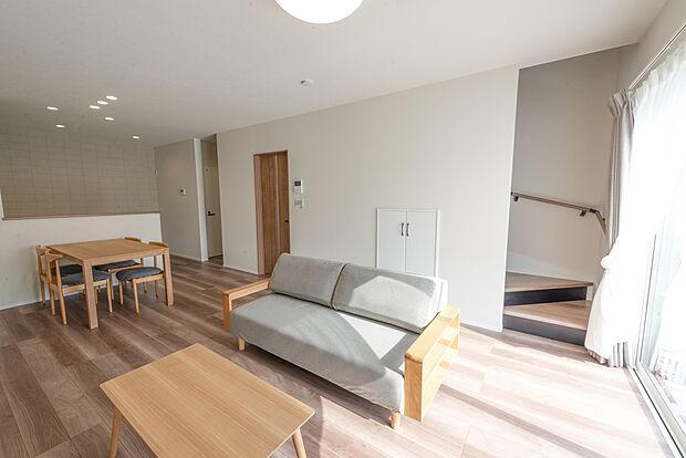 【【1階約17.8LDK帖/A号地モデルハウス】】約17.8帖のゆとりある団らん空間は、大きな南窓をはじめ、多面採光で陽光がたっぷりと注ぎ込みます。リビング階段下スペースは収納となっており、ブランケットなどのご家族共用品がスッキリ。視界が広がる開放感に包まれ、おうち時間がより好きになりそうです。