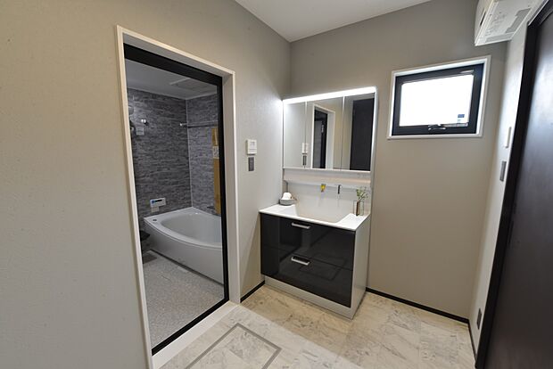 【【1階洗面脱衣室/B号地モデルハウス】】お手入れのしやすい、壁付け水栓タイプの洗面化粧台を採用。鏡裏とボウル下に収納できる他、キッチンと繋がる便利な収納も備えています。