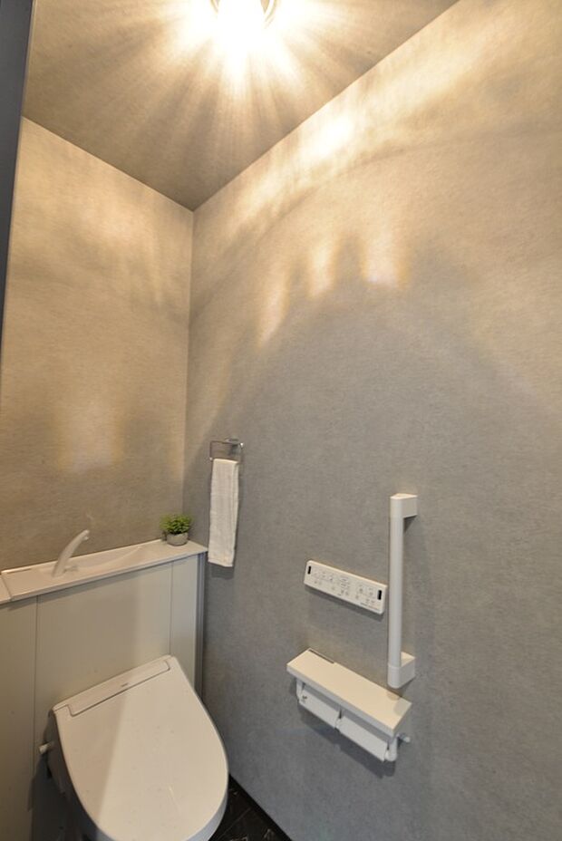 【【1階トイレ/B号地モデルハウス】】トイレはお手入れが楽で節水にも繋がり、タンクが視界に入らずスッキリ。温水洗浄便座付きです。操作パネルは壁付けタイプなので、かがまずに楽な姿勢で利用できます。