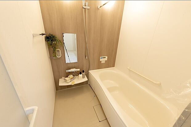 【【1階浴室/D号地】】木目調のアクセントパネルによりナチュラルな印象です。浴槽は半身浴の際などに便利なベンチ型。浴室暖房乾燥機付きのため、寒い季節はあらかじめ浴室全体を暖めてから入浴いただけます。