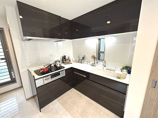 【アーバンポート施工例】お手入れのしやすい人工大理石トップのシステムキッチン。収納スペースも豊富。３口コンロでお料理の幅も広がりますね。
