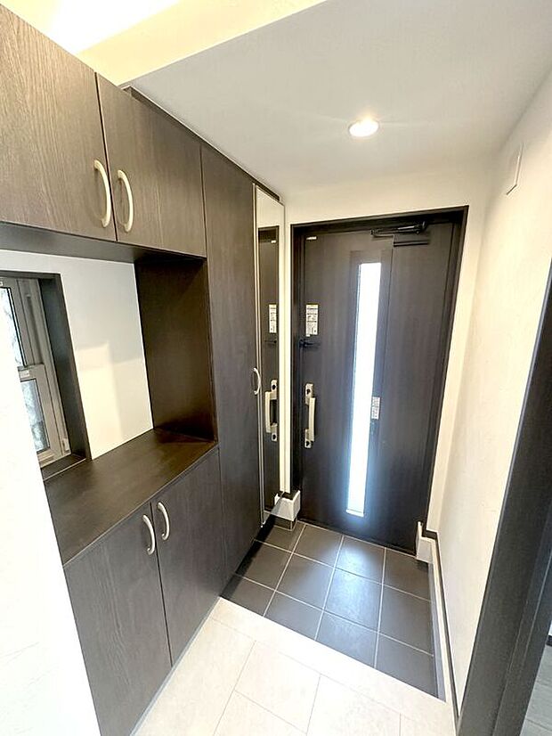 【玄関】大容量のトールタイプの玄関収納つき。姿見付きですのでお出かけ前のチェックにも便利。【A号棟 2025年7月撮影】