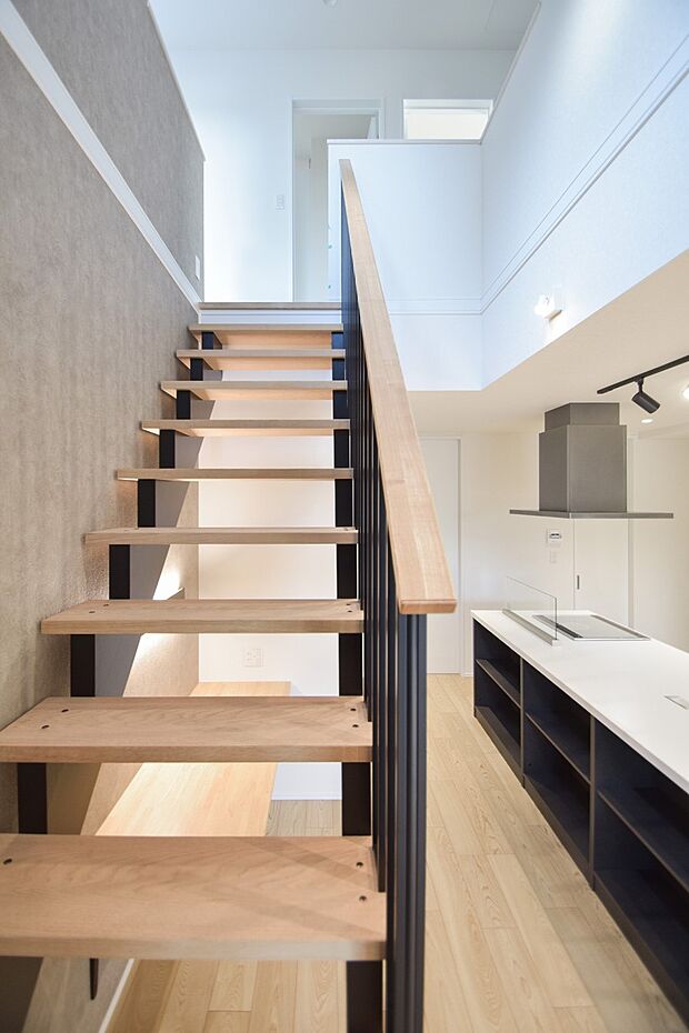 【その他内観】吹抜けを抜ける光とラインが重なり合い、リビングに奥行きを添える階段の視点。（2号棟｜2025年12月撮影）