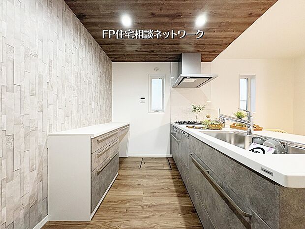 【キッチン】【キッチン】 木目調の天井とグレーの石目調キッチンが織りなす、洗練されたカフェのような空間。充実のカップボードで収納力も抜群です。質感豊かなアクセントクロスが、日々の料理時間を上質なひとときへと変え