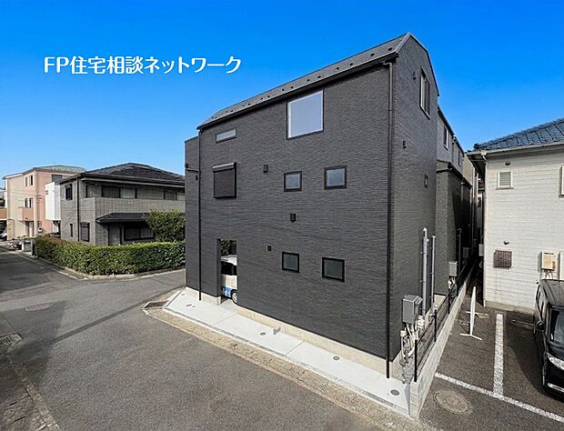 【前面道路含む現地写真】重厚感のあるダークトーンを基調とした、スタイリッシュな外観デザイン。窓をバランスよく配置し、すっきりとした美しいフォルムに仕上げた、都市的な存在感のある住まいです。