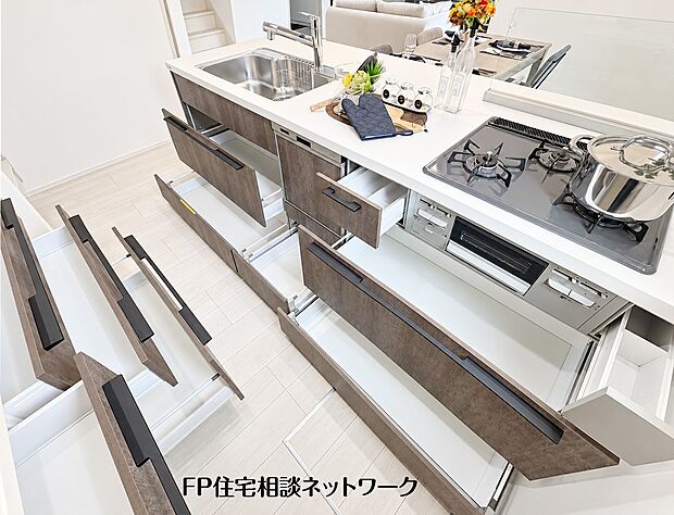 【キッチン】システムキッチンは収納力が豊富で、引き出しを開けると奥の調理器具まで見渡せます。コンロ下やシンク下にも深さのあるスペースが確保され、大きなお鍋などもすっきりと整理整頓できます。