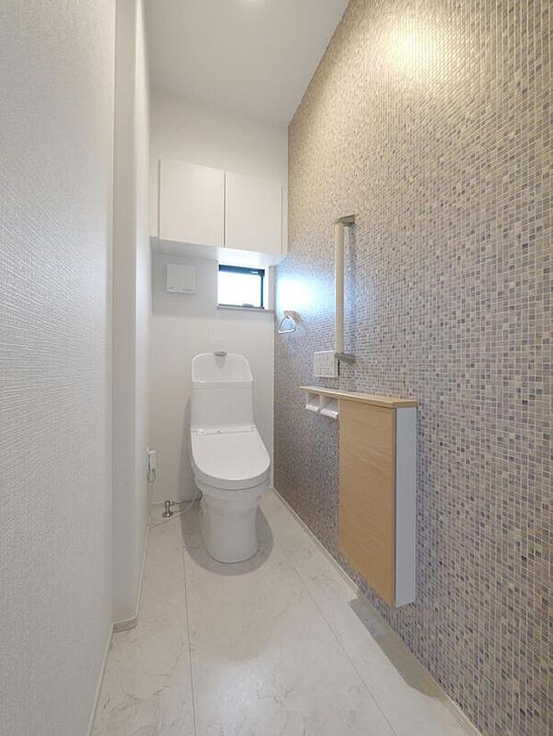 【【B-6棟　1Fトイレ】】側面2箇所に収納を有した1Fトイレ。掃除用品など収納できて、スッキリとした印象を受けます。快適な温水洗浄便座付きのトイレです。