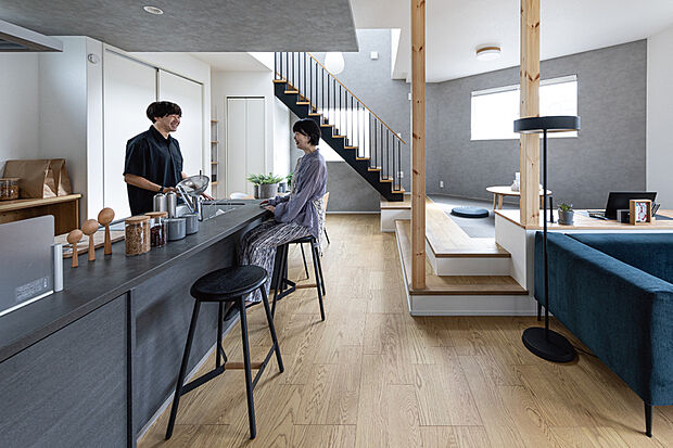 【開放的な段差空間のある暮らし】
リビングの一角に段差空間がユニークなステージリビングを設けました。縦の空間を強調する吹き抜けとデザイン階段が開放感を生み出します。(23号棟/2025年9月撮影)