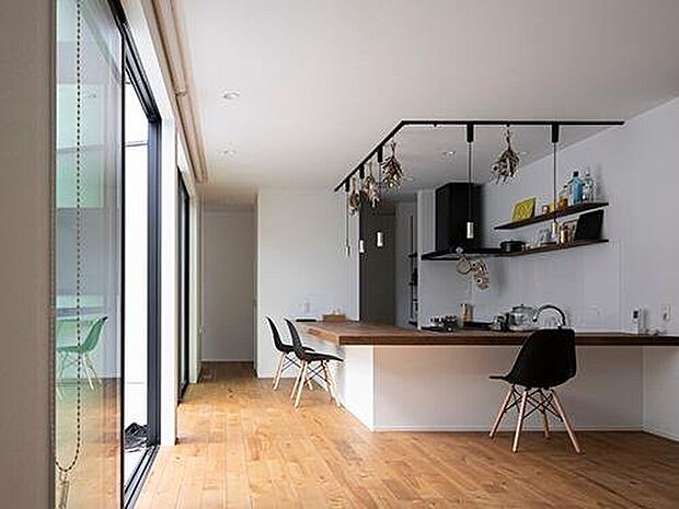 【【プラン例】】ご夫婦お気に入りのカウンターキッチン。ダイニングテーブルも兼ねているので、空間が広く使える。左側には大きな窓があり、中庭と繋がっている。