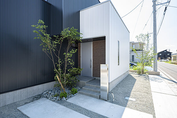 黒の外壁に植栽が映える玄関ポーチ