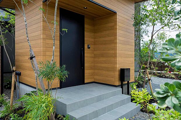 【玄関ポーチ】木目×ブラック×植栽が美しく調和する。