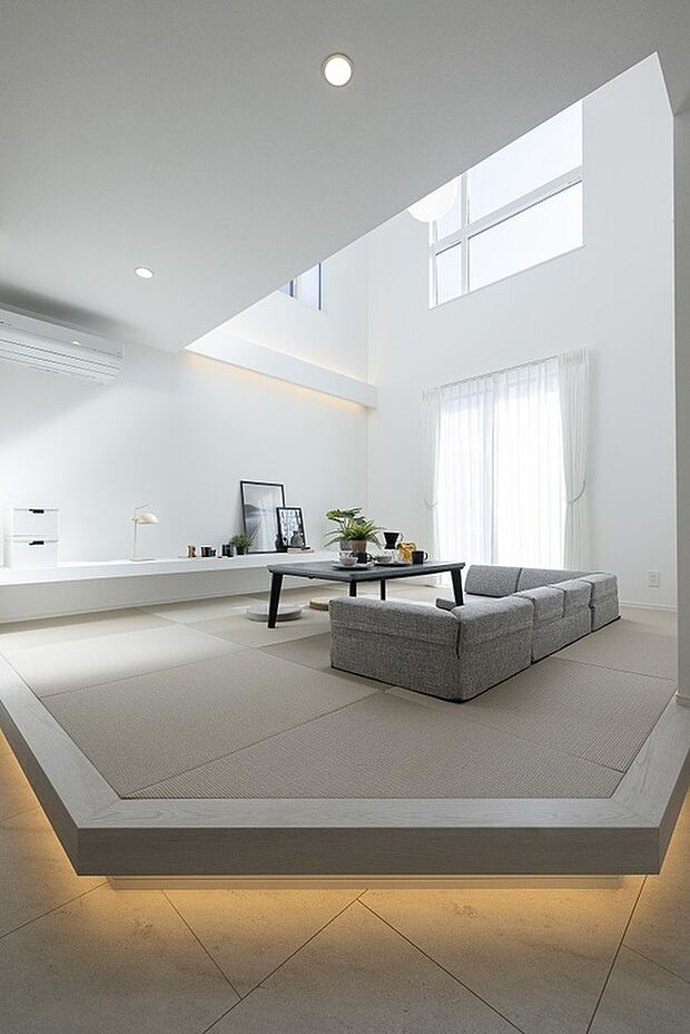 【【1階約19.39帖LDK/当社施工例】】リビングは小上がりの畳敷きスペースに。フロアの高さを変えることで、キッチンやダイニングスペースと緩やかに空間をゾーニング。緑のない琉球畳や間接照明を取り入れることで、洋の空間に溶け込むモダンスタイルです。/建物価格2761.1万円、建物面積96.47m2、3LDK