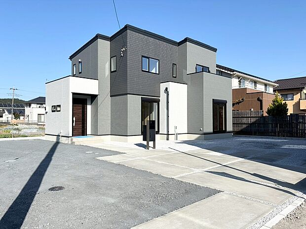 【1号棟:外観】建物完成。３色を組み合わせたスタイリッシュなファサードが魅力。シンプルながら存在感のあるお住まいです。広々とした駐車スペースも完備。