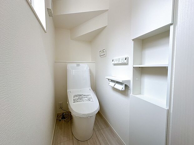 【【2号棟：トイレ】】フチレス形状やお掃除リフトアップ機能などお手入れのしやすさが特徴。壁設置型のリモコンと２連紙巻き器が備え付けとなっている超節水タイプの温水洗浄便座です。（2025年8月4日撮影）