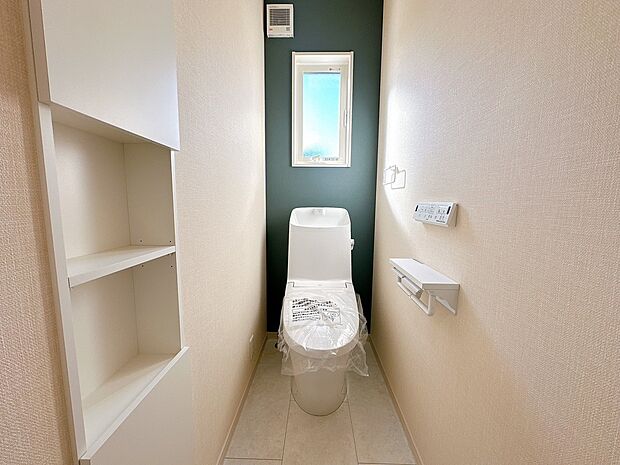 【【1号棟　トイレ】】フチレス形状やお掃除リフトアップ機能などお手入れのしやすさが特徴。壁設置型のリモコンと２連紙巻き器が備え付けとなっている超節水タイプの温水洗浄便座です。（2025年10月2日撮影）