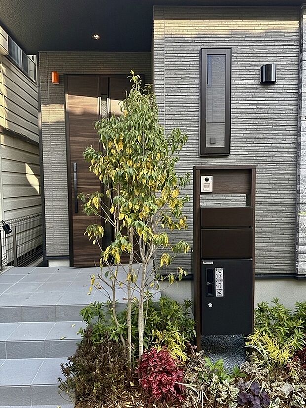 【玄関】美しい植栽が四季の彩りを添える玄関アプローチ。住まいの顔として、ゲストを優雅に迎えます。※現地写真(2026年3月撮影)