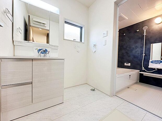 【洗面台・洗面所】白を基調とした清潔感のある洗面所スペース。洗面台は人気の三面鏡仕様。使い勝手の良さはもちろん、鏡の裏が収納になっており見える範囲をスッキリとすることができます。