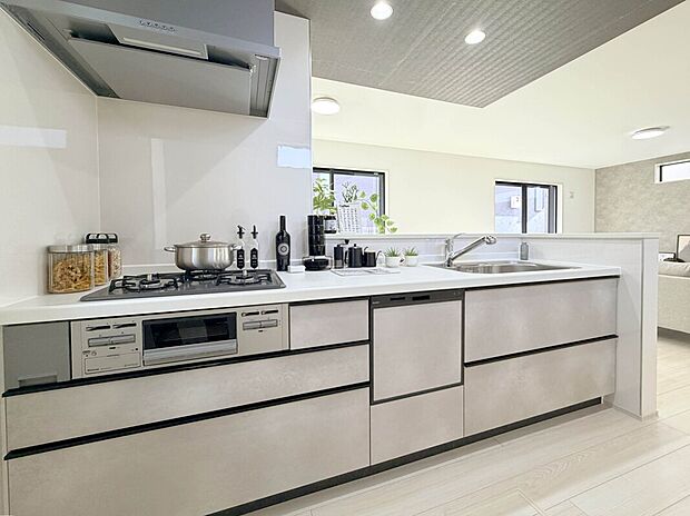 【【建物プラン例：Kitchen】】リビングとキッチンの天井にあえて段差を作る事で、空間に深みをもたらす折下天井を採用。開放感とメリハリを両立させました。キッチンとリビング双方から声掛けや見守りがしやすく、自然と会話も弾みます。