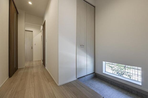 【玄関【1号地】（2025年7月撮影）】複数人でも使い易いＬ型玄関は地窓がアクセントに