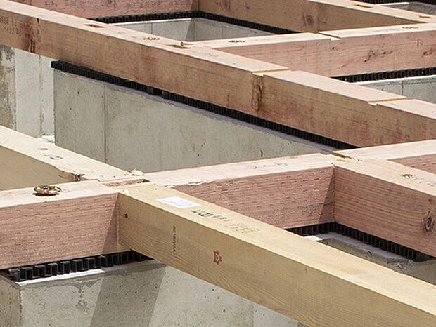 【剛性・耐久性にすぐれた「ベタ基礎」】コンクリートで建物の下一面を支える工法。 基礎鉄筋を張り、強度を高めたベタ基礎の耐圧盤を1階の床下全面に施工し、広い耐圧盤の面で建物の荷重を地盤に伝えます。