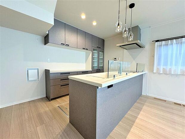 【【D号地 2024年8月撮影】キッチン】コーディネートされた明るい空間のキッチンエリアはカップボード付きで収納力◎