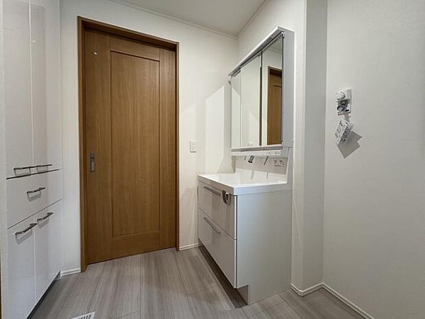 【A棟洗面脱衣室】玄関とキッチンどちらからもアクセス可能 背面収納付きでタオルや日用品もすっぽり収まる実用的な設計です。(2025年7月撮影)