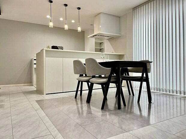 カウンター下のたっぷり収納でLDKもすっきり整います。上質な床タイルとこだわりの照明がホテルのような落ち着きを演出し、家族が自然と集まる心地よいダイニング空間です。