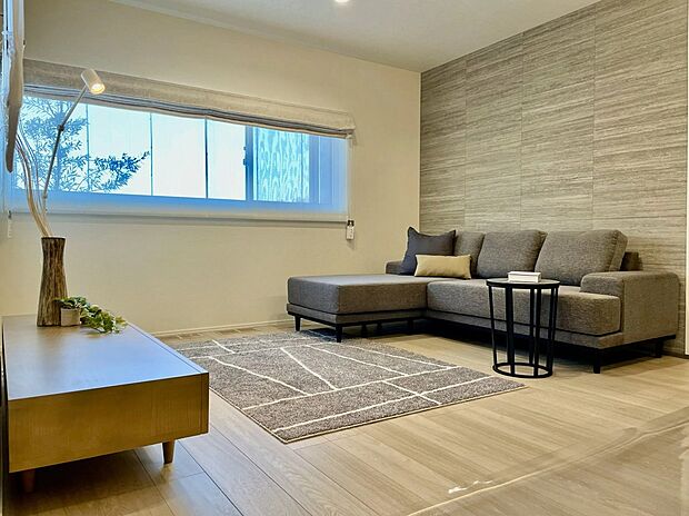 石目調のアクセントウォールが上質な雰囲気を演出するリビング。コーナー開口で光を取り込みつつ視線はやさしく遮ります。18.2畳の広さを活かした、開放感と落ち着きのある空間です。