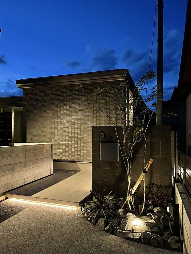 玄関前は広いタイルデッキと植栽で高級感を演出。ゲストを気持ち良くお出迎えできます。夜間はライトアップにより、上質で洗練された雰囲気を演出し、昼とは異なる美しい表情を楽しめます。