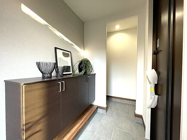 【玄関】落ち着いた色合いで統一された玄関空間。収納力のあるシューズボックスとやわらかな採光が、上質で心地よい第一印象を演出します。