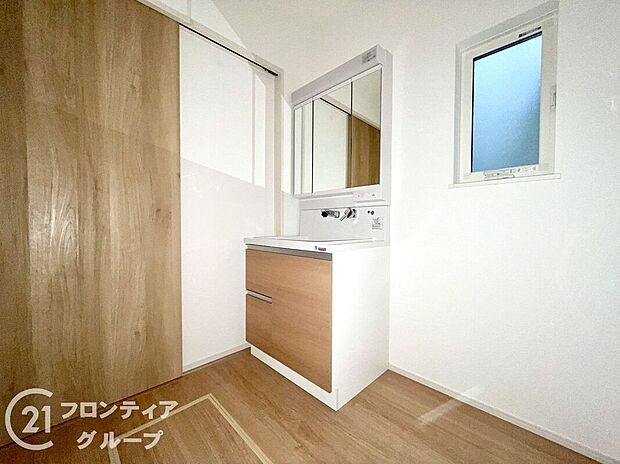【洗面】広々としたカウンターと三面鏡を備えた洗面台。収納も充実しており、朝の支度もスムーズ。隣接する洗濯機置き場との動線もよく、清潔感と使い勝手を兼ね備えた家族に嬉しい空間です。