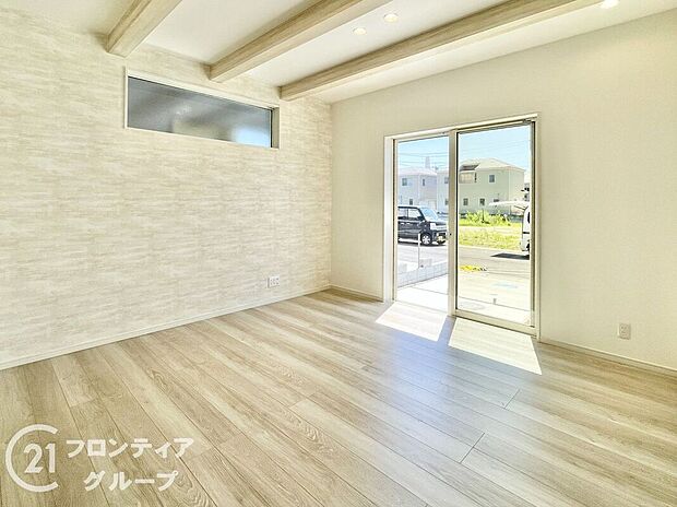 【リビング】ナチュラルな木目調のフローリングと落ち着いたトーンのクロスが調和したリビング。大きな掃き出し窓が開放感を演出し、外の風景と心地よくつながります。家族との時間も一人の時間も楽しめる理想的な居住空間です。