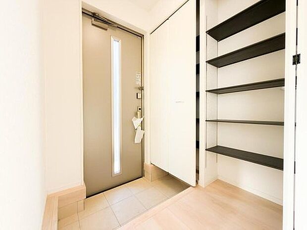 【玄関】陽光が差し込む明るい玄関は、家族の「ただいま」を優しく迎えます。大容量のシューズクロークで、靴やベビーカーもすっきり収納でき、いつも清潔な空間を保てます。