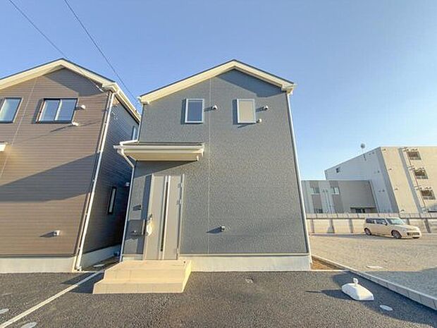【現地外観写真】青空に映える、スタイリッシュな外観が魅力の戸建て。ゆとりのある駐車スペースで、家族のカーライフも快適に。新しい暮らしがここから始まります。
