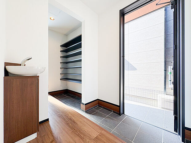 【=シューズクローク=】玄関に隣接したシューズインクローゼットは、靴や傘、アウトドアグッズなどの収納に便利です。玄関がすっきり片付き、広く快適に使えるため、日々の生活がさらに快適になります。(2号棟)