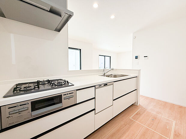 【ー対面式キッチンー】（A号棟）広々とした対面式システムキッチン。使いやすい動線と豊富な収納スペースで家事効率が上がり、リビングとつながる開放的な設計でだんらんを感じながら調理できます。