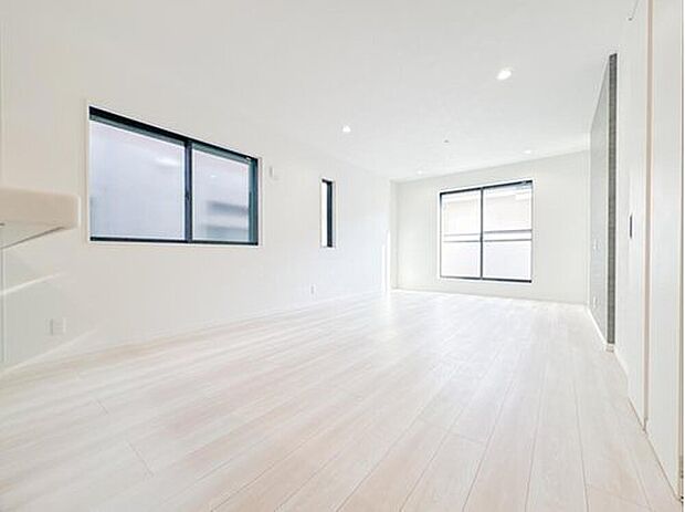 白を基調とした、光溢れる明るいリビング。複層ガラスを採用した窓からは柔らかな陽光が差し込み、開放的な空間を演出します。清潔感のあるフローリングとダウンライトが、心地よい家族の団らんを優しく包みます。