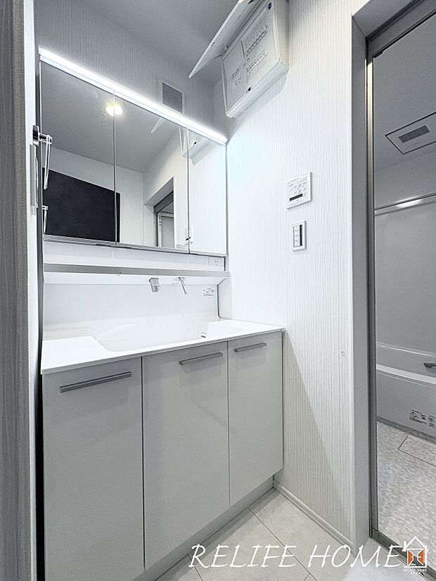 【三面鏡洗面化粧台】見た目の美しさだけではなく、機能性も追求した使い勝手の良い鏡裏収納付3面鏡型の独立洗面化粧台。広めで使いやすい、お手入れが楽なデザインのカウンターに収納豊富なキャビネット。(5号棟)