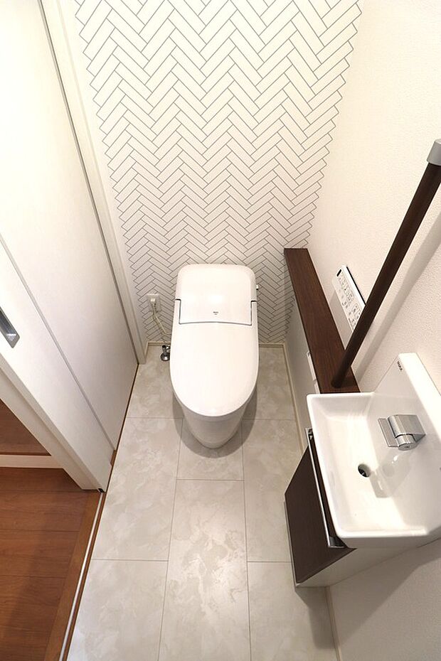 【ロータンクシャワートイレ+手洗いカウンター】1Fトイレはすっきりとしたタンクレス風デザインの便器と、手洗いカウンター、シャワートイレリモコンや手すり、2連紙巻が標準で付いています。すべてLIXIL製（No.12）