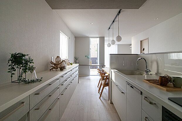 【■No.1/キッチン】キッチンとカップボードの先にスリムで美しい窓を配置。視線が自然と外へ運ばれるため、行き止まりを感じさせない、広々とした開放感を演出しています。