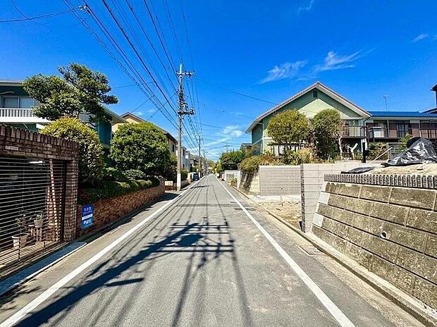 【現地外観写真】澄み渡る青空が広がる、開放的な住宅街の風景。電線が張り巡らされた日本の街並みは、どこか懐かしさを感じさせます。お子様との散歩も安心の、穏やかな住環境です。