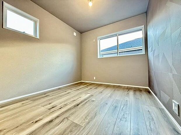 【リビング以外の居室】木目調の床に柔らかな陽光が差し込む、温かみあふれる居室。