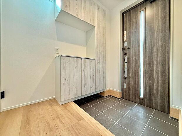 【玄関】広めの玄関スペースで、靴や傘の収納がしやすく、毎日の出入りもスムーズです。玄関に窓があり、自然光が入りやすく明るい空間になっています。