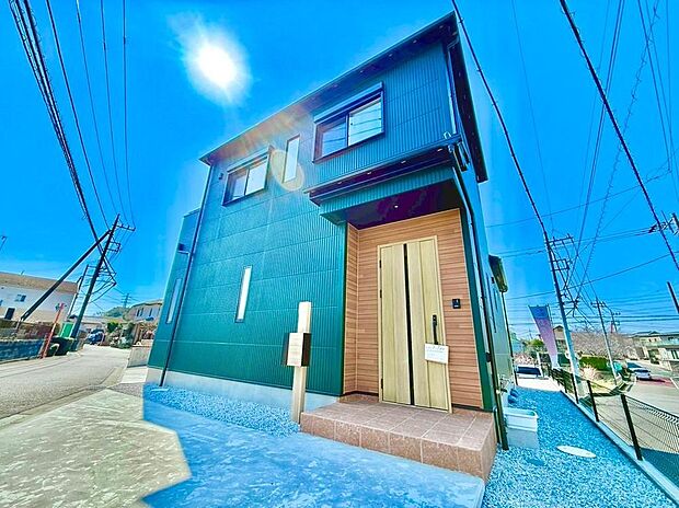 【現地外観写真】高級感のあるグリーンの外壁に、温かな木目調のドアと軒天を組み合わせたエントランス。ゆとりあるポーチ部分は、雨の日のお子様の出入りや、お買い物帰りの荷物置きにも便利。