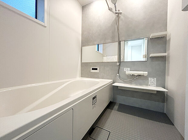 【浴室　A号棟】リクシル　システムバスルーム「AX」
【キレイサーモフロア】スポンジが奥まで入り、お掃除ラクラク。独自の断熱層で寒い冬場でもヒヤッとしません。
【サーモバスS】
浴槽保温材と保温組フタのダブル保温で、時間が経っても浴槽内の温度を最小限に抑えます。
半身浴のできるベンチ付きの節水型の浴槽、排水口はシャワーなどの排水時に渦を起こして髪の毛やゴミをまとめてくれるためお掃除簡単で汚れもつきにくい構造になっています。