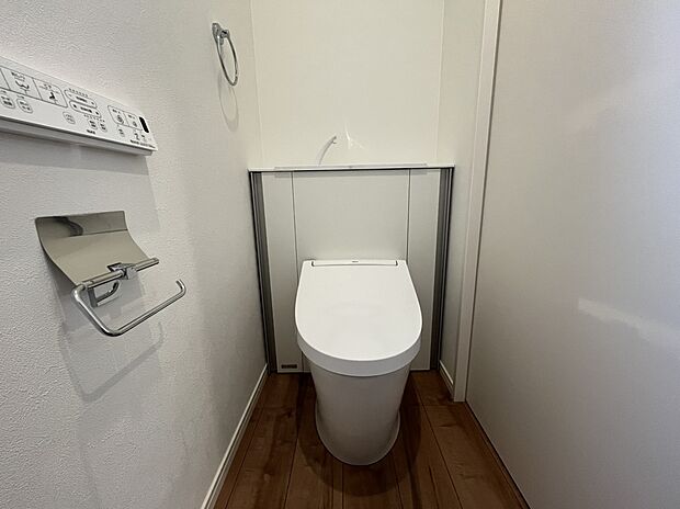 【トイレ　A号棟現地写真】■INAX　「ベーシアピタ フチレス」。汚れにくくお掃除のしやすいフチレス形状の便器を採用することで少ない水でもしっかり汚れを洗い流し、清潔でデザイン性のある空間を実現します。