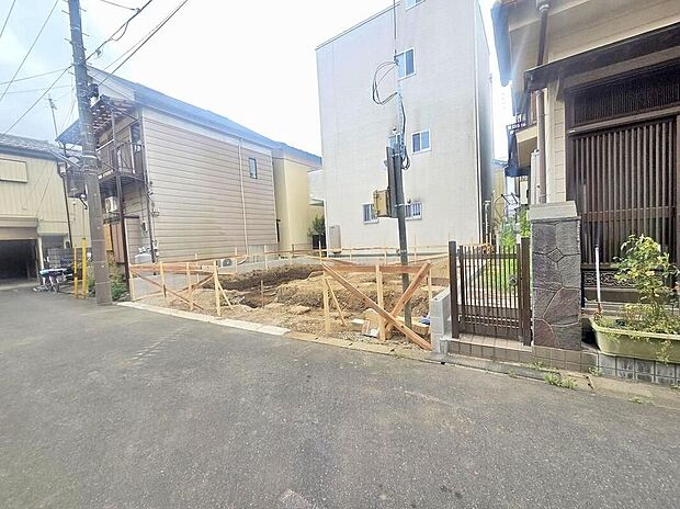 【前面道路含む現地写真】木枠で囲われた整地中の敷地写真です。東側4m私道に面しており、土地面積63.07m2。完成は2026年10月予定、駐車1台可。現地（2026年8月）撮影